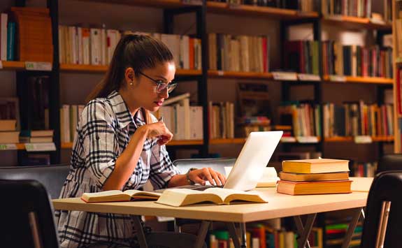 Student studying on a laptop in the library